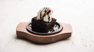 Cızırdayan çikolatalı brownie, üzerine bol bol eritilmiş çikolata dökülerek servis edilen bir top dondurmayla yapılan tatlı bir yemektir. Sunucu sıcak. seçici odak