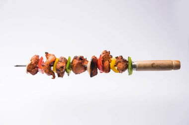 Tavuk tikka/Kebap çarpık. Geleneksel Hint yemeği kömür ve alev üzerinde pişmiş, terbiyeli ve rengarenk süslenmiş. yeşil Hint turşusu ve salata ile servis. seçici odak
