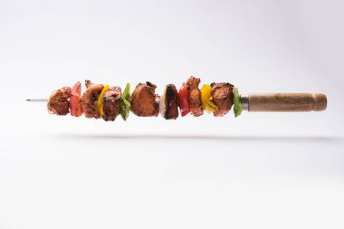 Chicken tikka /skew Kebab. Traditional Indian dish cooked on charcoal and flame, seasoned & colourfully garnished. served with green chutney and salad. selective focus clipart