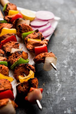 Tavuk tikka/Kebap çarpık. Geleneksel Hint yemeği kömür ve alev üzerinde pişmiş, terbiyeli ve rengarenk süslenmiş. yeşil Hint turşusu ve salata ile servis. seçici odak