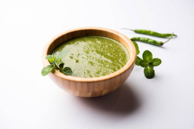 Sağlıklı yeşil nane Hint turşusu yapılan kişniş, pudina ve baharatlar ile. izole moody arka plan. seçici odak