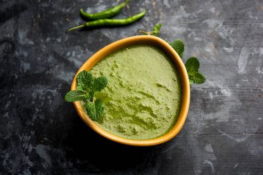 Sağlıklı yeşil nane Hint turşusu yapılan kişniş, pudina ve baharatlar ile. izole moody arka plan. seçici odak