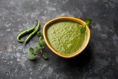 Sağlıklı yeşil nane Hint turşusu yapılan kişniş, pudina ve baharatlar ile. izole moody arka plan. seçici odak