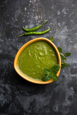 Sağlıklı yeşil nane Hint turşusu yapılan kişniş, pudina ve baharatlar ile. izole moody arka plan. seçici odak