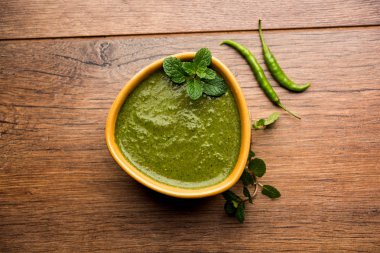 Sağlıklı yeşil nane Hint turşusu yapılan kişniş, pudina ve baharatlar ile. izole moody arka plan. seçici odak