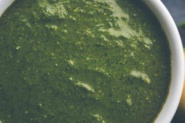 Sağlıklı yeşil nane Hint turşusu yapılan kişniş, pudina ve baharatlar ile. izole moody arka plan. seçici odak