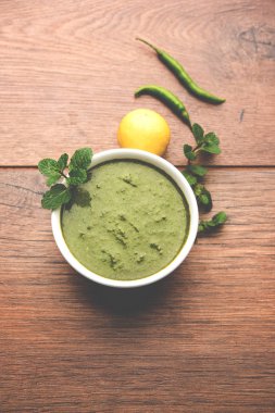 Sağlıklı yeşil nane Hint turşusu yapılan kişniş, pudina ve baharatlar ile. izole moody arka plan. seçici odak