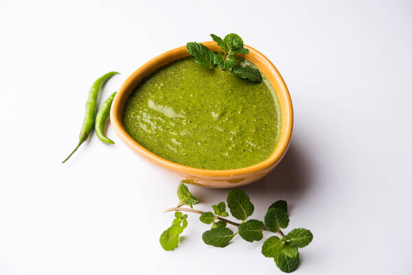 Healthy Green Mint Chutney Made with Coriander, pudina And Spices. isolated moody background. selective focus