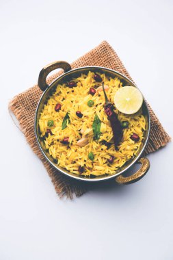 Limon pirinç kalan pirinç süslenmiş fındık köri yaprakları ve limon suyu, seçici odak kullanarak fodnicha bhat denilen bir Güney Hint zerdeçal pirinç veya maharashtrian reçetedir