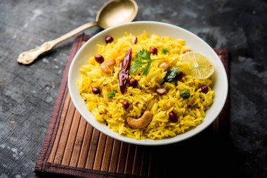 Limon pirinç kalan pirinç süslenmiş fındık köri yaprakları ve limon suyu, seçici odak kullanarak fodnicha bhat denilen bir Güney Hint zerdeçal pirinç veya maharashtrian reçetedir