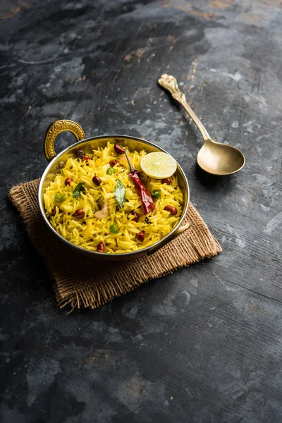 stock image Lemon Rice is a South Indian turmeric rice or maharashtrian recipe called fodnicha bhat using leftover rice garnished with nuts curry leaves and lemon juice, selective focus