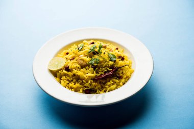 Limon pirinç kalan pirinç süslenmiş fındık köri yaprakları ve limon suyu, seçici odak kullanarak fodnicha bhat denilen bir Güney Hint zerdeçal pirinç veya maharashtrian reçetedir