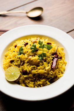 Limon pirinç kalan pirinç süslenmiş fındık köri yaprakları ve limon suyu, seçici odak kullanarak fodnicha bhat denilen bir Güney Hint zerdeçal pirinç veya maharashtrian reçetedir