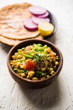 Paneer Bhurji, hafif pütürlü kapış baharatlı ve roti veya laccha paratha, seçici odak ile hizmet
