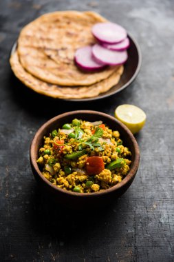 Paneer Bhurji, hafif pütürlü kapış baharatlı ve roti veya laccha paratha, seçici odak ile hizmet