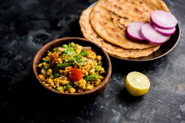 Paneer Bhurji, hafif pütürlü kapış baharatlı ve roti veya laccha paratha, seçici odak ile hizmet