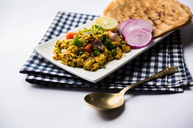 Paneer Bhurji, hafif pütürlü kapış baharatlı ve roti veya laccha paratha, seçici odak ile hizmet