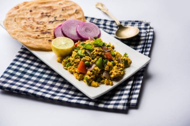 Paneer Bhurji, hafif pütürlü kapış baharatlı ve roti veya laccha paratha, seçici odak ile hizmet