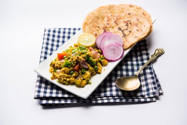 Paneer Bhurji, hafif pütürlü kapış baharatlı ve roti veya laccha paratha, seçici odak ile hizmet