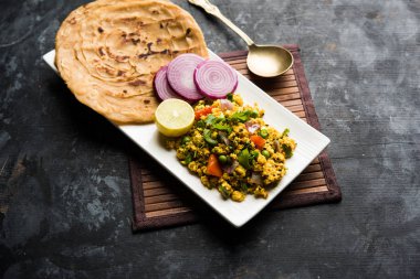 Paneer Bhurji, hafif pütürlü kapış baharatlı ve roti veya laccha paratha, seçici odak ile hizmet