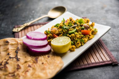 Paneer Bhurji, hafif pütürlü kapış baharatlı ve roti veya laccha paratha, seçici odak ile hizmet