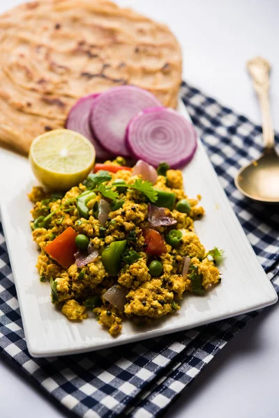 Paneer Bhurji, hafif pütürlü kapış baharatlı ve roti veya laccha paratha, seçici odak ile hizmet