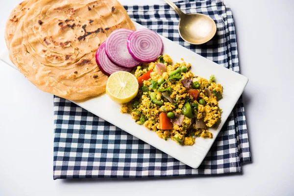 Paneer Bhurji, hafif pütürlü kapış baharatlı ve roti veya laccha paratha, seçici odak ile hizmet