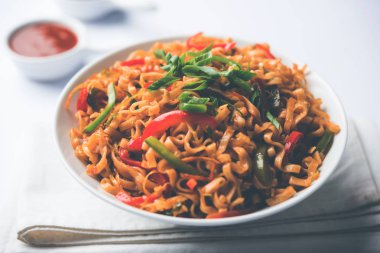 Baharatlı ve lezzetli heyecan düz Hakka noodles sosu ve sebzeler ile kızarmış Schezwan sebze erişte var. çubuklarla servis. seçici odak