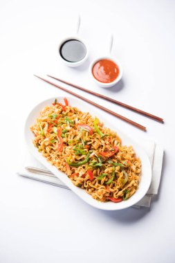 Baharatlı ve lezzetli heyecan düz Hakka noodles sosu ve sebzeler ile kızarmış Schezwan sebze erişte var. çubuklarla servis. seçici odak