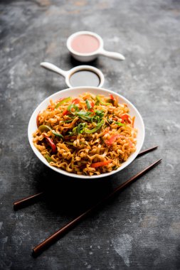 Baharatlı ve lezzetli heyecan düz Hakka noodles sosu ve sebzeler ile kızarmış Schezwan sebze erişte var. çubuklarla servis. seçici odak