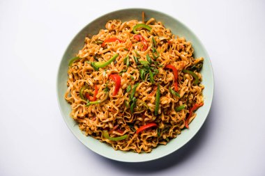 Baharatlı ve lezzetli heyecan düz Hakka noodles sosu ve sebzeler ile kızarmış Schezwan sebze erişte var. çubuklarla servis. seçici odak