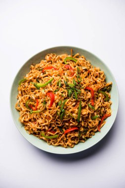 Baharatlı ve lezzetli heyecan düz Hakka noodles sosu ve sebzeler ile kızarmış Schezwan sebze erişte var. çubuklarla servis. seçici odak