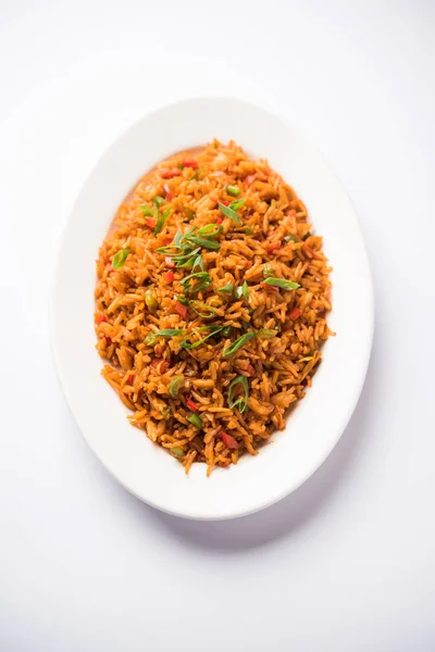 Schezwan 揚げ米マサラは箸で皿やボウルでお召し上がりいただけます人気のインド中華料理です 選択と集中 — ストック写真