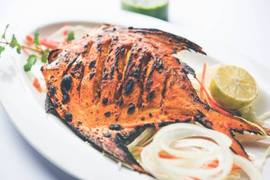Tandır Pomfret balık kil fırında pişmiş ve limon, nane, lahana ve havuç salatası ile süslenmiş. Seçici odak