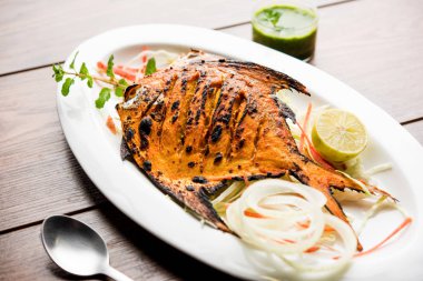 Tandır Pomfret balık kil fırında pişmiş ve limon, nane, lahana ve havuç salatası ile süslenmiş. Seçici odak