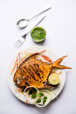 Tandır Pomfret balık kil fırında pişmiş ve limon, nane, lahana ve havuç salatası ile süslenmiş. Seçici odak