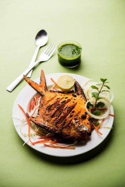 Tandır Pomfret balık kil fırında pişmiş ve limon, nane, lahana ve havuç salatası ile süslenmiş. Seçici odak