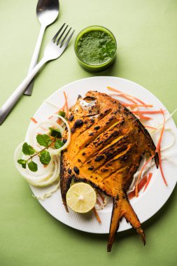 Tandır Pomfret balık kil fırında pişmiş ve limon, nane, lahana ve havuç salatası ile süslenmiş. Seçici odak