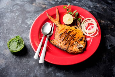 Tandır Pomfret balık kil fırında pişmiş ve limon, nane, lahana ve havuç salatası ile süslenmiş. Seçici odak