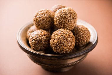 Tilgul Laddu veya Til Gul topu için makar sankranti, susam, ezilmiş fıstık ve jaggery kullanılarak yapılan bir sağlıklı besindir. bir kasede servis. seçici odak gösteren Ayrıntılar.