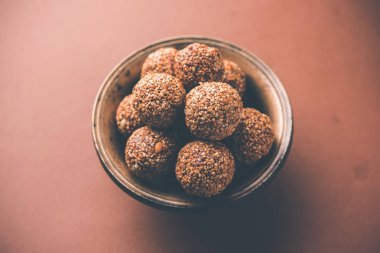 Tilgul Laddu veya Til Gul topu için makar sankranti, susam, ezilmiş fıstık ve jaggery kullanılarak yapılan bir sağlıklı besindir. bir kasede servis. seçici odak gösteren Ayrıntılar.