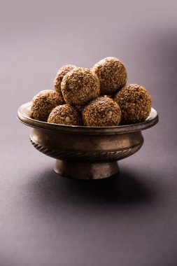 Tilgul Laddu veya Til Gul topu için makar sankranti, susam, ezilmiş fıstık ve jaggery kullanılarak yapılan bir sağlıklı besindir. bir kasede servis. seçici odak gösteren Ayrıntılar.