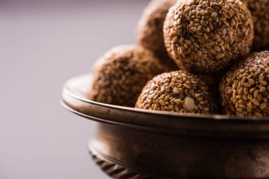 Tilgul Laddu veya Til Gul topu için makar sankranti, susam, ezilmiş fıstık ve jaggery kullanılarak yapılan bir sağlıklı besindir. bir kasede servis. seçici odak gösteren Ayrıntılar.