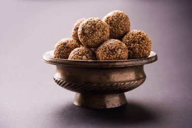 Tilgul Laddu veya Til Gul topu için makar sankranti, susam, ezilmiş fıstık ve jaggery kullanılarak yapılan bir sağlıklı besindir. bir kasede servis. seçici odak gösteren Ayrıntılar.