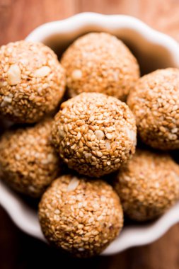Tilgul Laddu veya Til Gul topu için makar sankranti, susam, ezilmiş fıstık ve jaggery kullanılarak yapılan bir sağlıklı besindir. bir kasede servis. seçici odak gösteren Ayrıntılar.