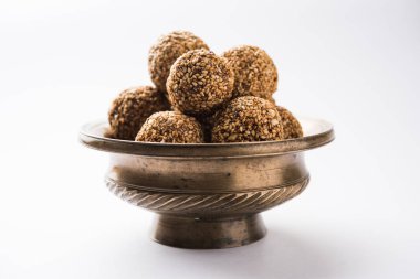 Tilgul Laddu veya Til Gul topu için makar sankranti, susam, ezilmiş fıstık ve jaggery kullanılarak yapılan bir sağlıklı besindir. bir kasede servis. seçici odak gösteren Ayrıntılar.