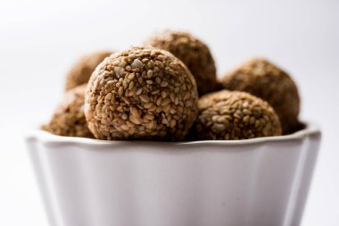 Tilgul Laddu veya Til Gul topu için makar sankranti, susam, ezilmiş fıstık ve jaggery kullanılarak yapılan bir sağlıklı besindir. bir kasede servis. seçici odak gösteren Ayrıntılar.