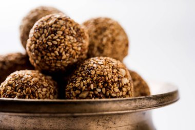Tilgul Laddu veya Til Gul topu için makar sankranti, susam, ezilmiş fıstık ve jaggery kullanılarak yapılan bir sağlıklı besindir. bir kasede servis. seçici odak gösteren Ayrıntılar.