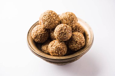 Tilgul Laddu veya Til Gul topu için makar sankranti, susam, ezilmiş fıstık ve jaggery kullanılarak yapılan bir sağlıklı besindir. bir kasede servis. seçici odak gösteren Ayrıntılar.