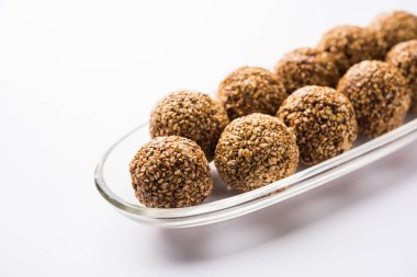 Tilgul Laddu veya Til Gul topu için makar sankranti, susam, ezilmiş fıstık ve jaggery kullanılarak yapılan bir sağlıklı besindir. bir kasede servis. seçici odak gösteren Ayrıntılar.